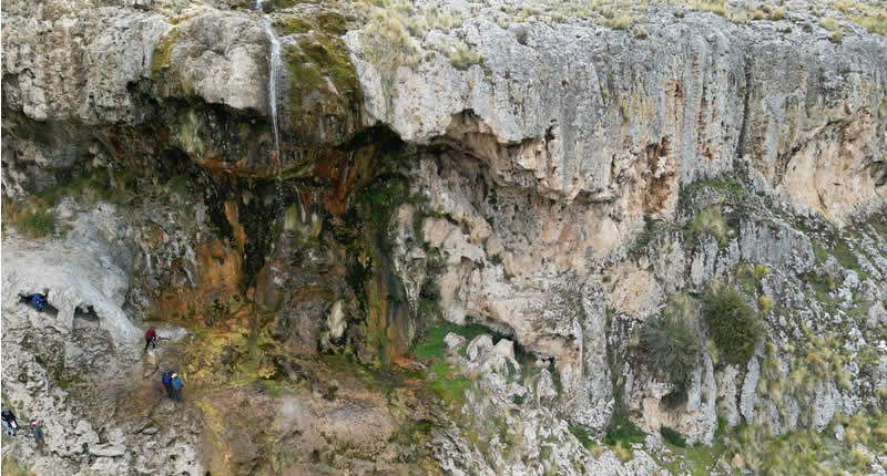 Cascada andina con poza natural y formas rocosas místicas