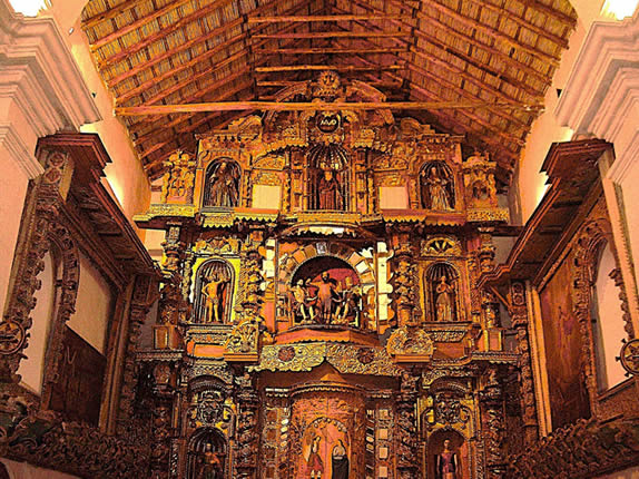 Innerer Hauptraum des Templo San Jerónimo in Asillo mit reich vergoldetem barocken Hauptaltar, zahlreichen geschnitzten Heiligenfiguren und traditionellem Holzdach